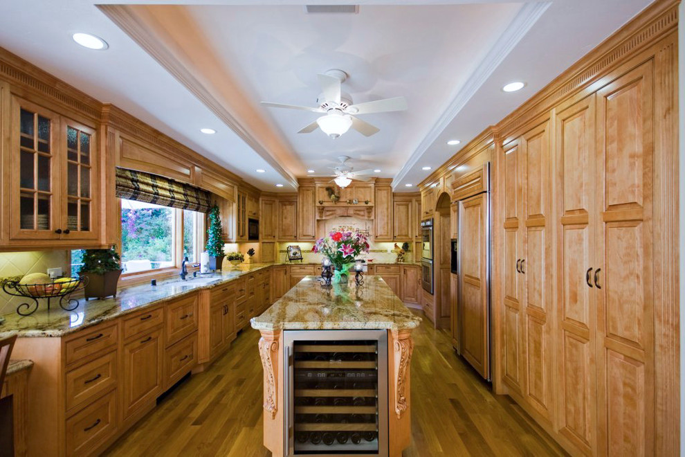 Exempel på ett stort amerikanskt kök, med en dubbel diskho, luckor med upphöjd panel, skåp i rostfritt stål, granitbänkskiva, beige stänkskydd, stänkskydd i keramik, rostfria vitvaror, mellanmörkt trägolv och en köksö