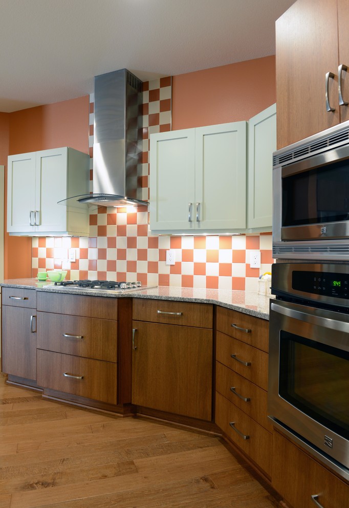 Modern inredning av ett mellanstort l-kök, med släta luckor, granitbänkskiva och en köksö
