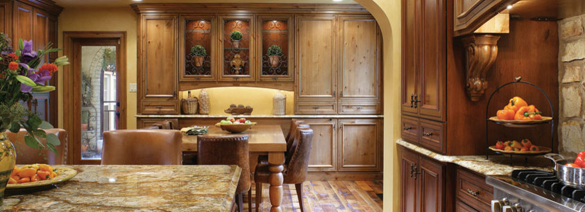Immagine di una cucina classica di medie dimensioni con ante con riquadro incassato, ante in legno scuro, top in granito, pavimento in legno massello medio, pavimento marrone e top marrone