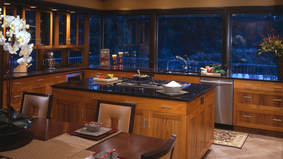Example of a minimalist u-shaped eat-in kitchen design in Seattle with an undermount sink, flat-panel cabinets, medium tone wood cabinets, granite countertops, multicolored backsplash, glass sheet backsplash and stainless steel appliances