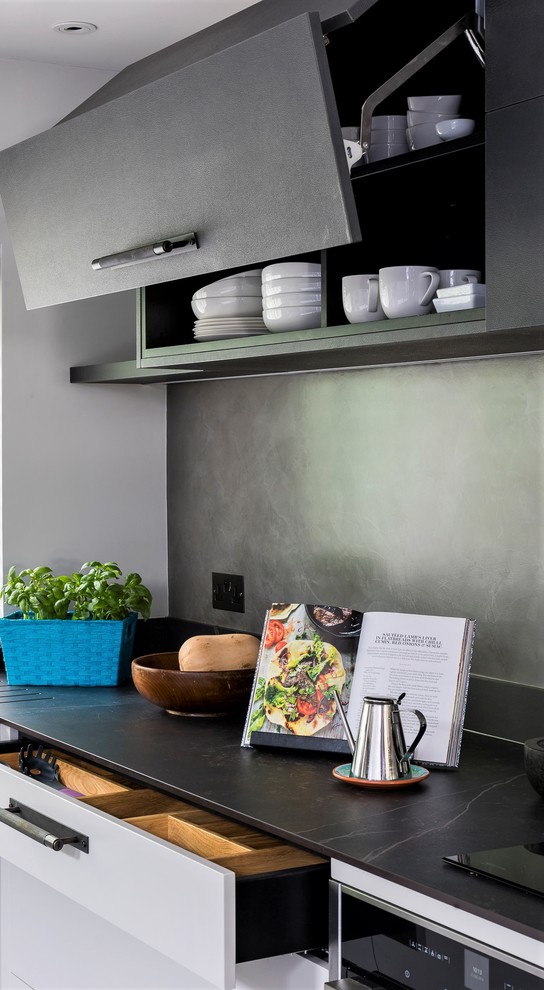 Пример оригинального дизайна: п-образная кухня среднего размера в современном стиле с обеденным столом и плоскими фасадами