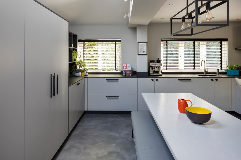 Medium sized contemporary u-shaped kitchen/diner in London with flat-panel cabinets.