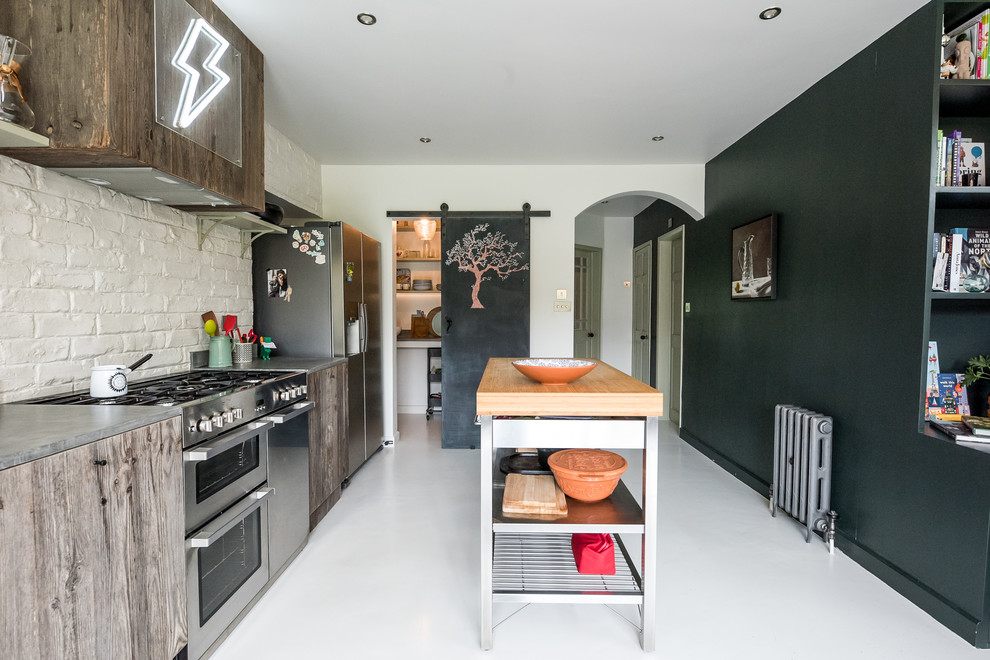 Inspiration för mellanstora eklektiska linjära grått kök med öppen planlösning, med en enkel diskho, släta luckor, skåp i mellenmörkt trä, bänkskiva i betong, vitt stänkskydd, stänkskydd i tegel, rostfria vitvaror, en köksö och vitt golv