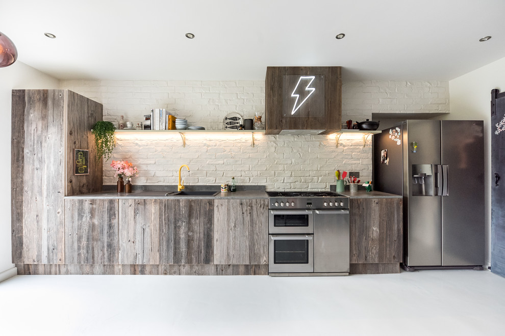 Exempel på ett mellanstort eklektiskt grå linjärt grått kök med öppen planlösning, med en enkel diskho, släta luckor, skåp i mellenmörkt trä, bänkskiva i betong, vitt stänkskydd, stänkskydd i tegel, rostfria vitvaror, en köksö och vitt golv
