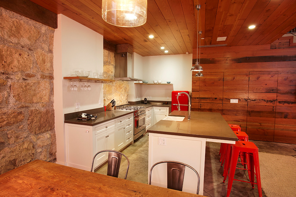 Modern inredning av ett litet kök, med en rustik diskho, skåp i shakerstil, vita skåp, bänkskiva i betong, vitt stänkskydd, stänkskydd i cementkakel, rostfria vitvaror, betonggolv och en köksö