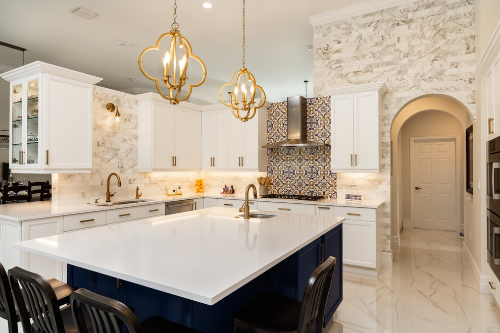 Inspiration for a large transitional u-shaped porcelain tile and white floor open concept kitchen remodel in Miami with an undermount sink, recessed-panel cabinets, white cabinets, quartz countertops, white backsplash, porcelain backsplash, stainless steel appliances, an island and white countertops