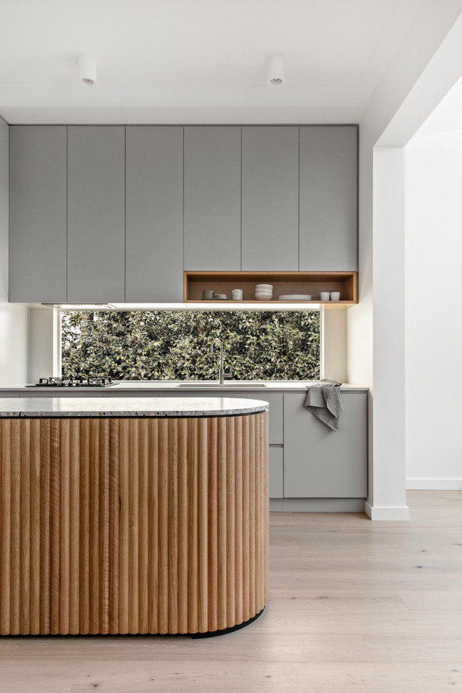 Foto di una piccola cucina design con lavello a doppia vasca, ante grigie, top alla veneziana, elettrodomestici neri, parquet chiaro e top grigio