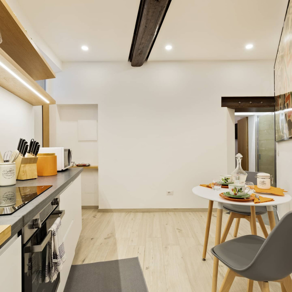 This is an example of a small contemporary single-wall kitchen/diner in Rome with a single-bowl sink, flat-panel cabinets, white cabinets, granite worktops, grey splashback, granite splashback, stainless steel appliances, porcelain flooring, no island, beige floors and grey worktops.