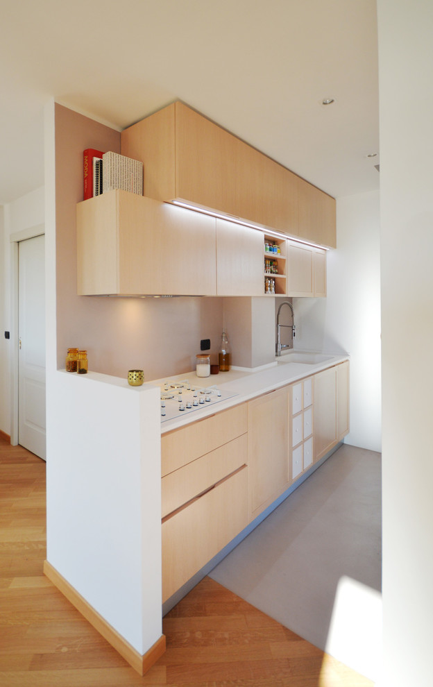 Пример оригинального дизайна: кухня среднего размера в современном стиле с светлыми деревянными фасадами и полуостровом