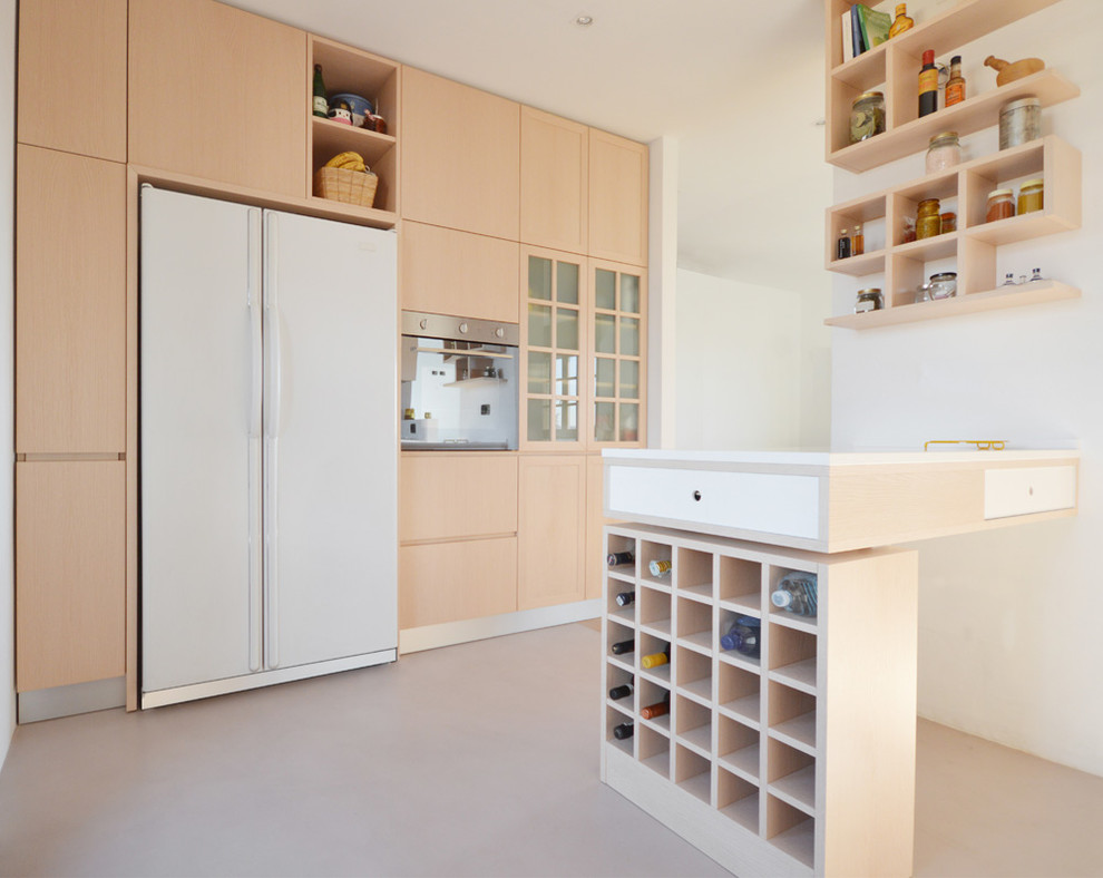 Cette image montre une cuisine design en bois clair de taille moyenne avec une péninsule, un placard à porte plane et un électroménager en acier inoxydable.