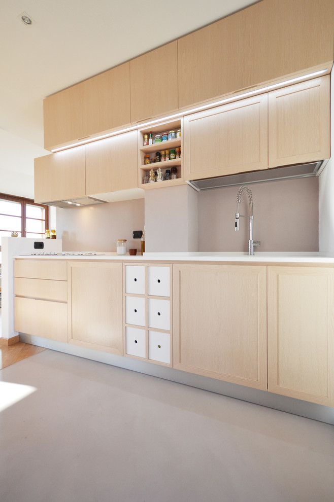 Idée de décoration pour une cuisine design en bois clair de taille moyenne avec une péninsule.