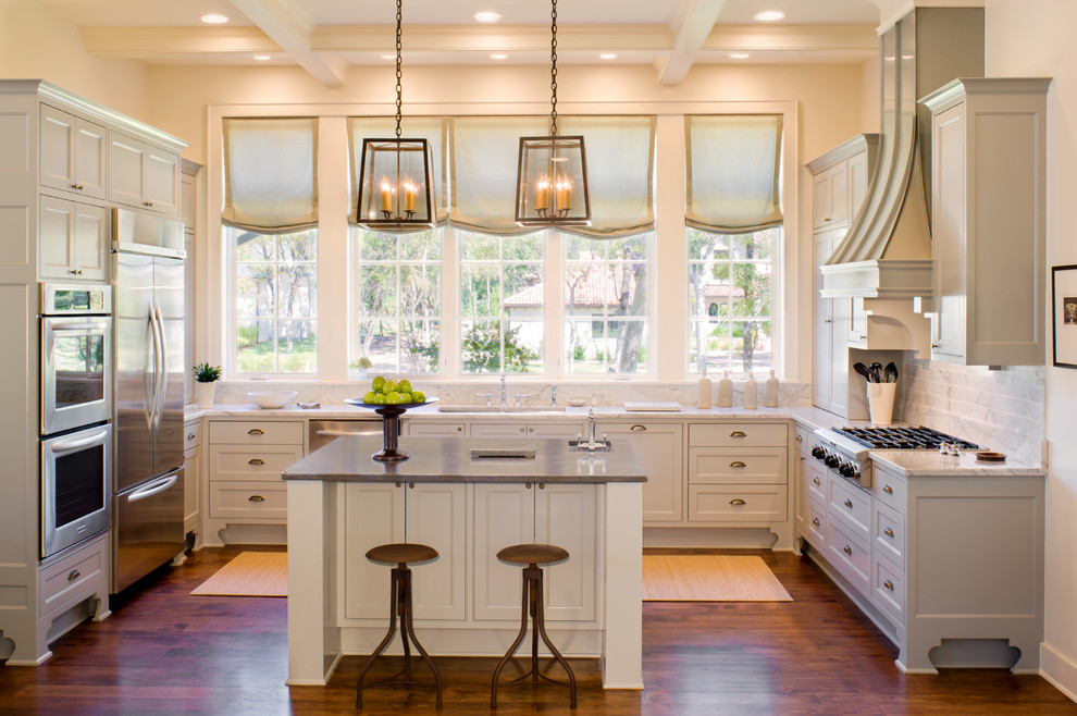 Inspiration for a transitional u-shaped dark wood floor and brown floor kitchen remodel in Austin with an undermount sink, shaker cabinets, white cabinets, white backsplash, stainless steel appliances, an island and gray countertops