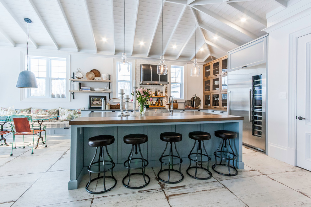Exemple d'une grande cuisine américaine nature avec un placard à porte shaker, des portes de placard bleues, un plan de travail en inox, un électroménager en acier inoxydable, un sol en carrelage de céramique, îlot, un sol blanc et un plan de travail gris.