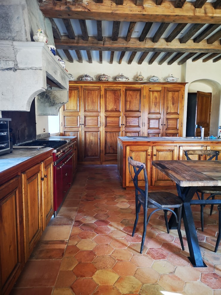 Foto di una grande cucina chic con lavello integrato, ante in legno scuro, top in pietra calcarea, paraspruzzi nero, pavimento in terracotta, pavimento arancione e top grigio