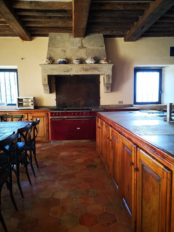 Immagine di una grande cucina chic con lavello integrato, ante in legno scuro, top in pietra calcarea, paraspruzzi nero, pavimento in terracotta, pavimento arancione e top grigio