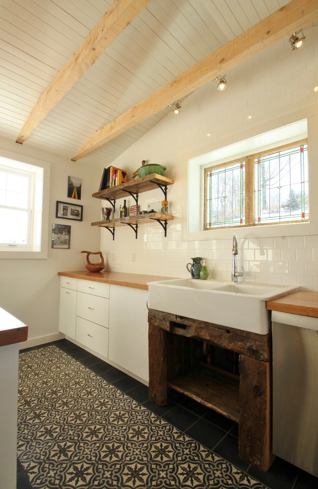Exempel på ett avskilt eklektiskt kök, med en rustik diskho, släta luckor, vita skåp, träbänkskiva, vitt stänkskydd, stänkskydd i keramik, rostfria vitvaror, klinkergolv i keramik och en halv köksö