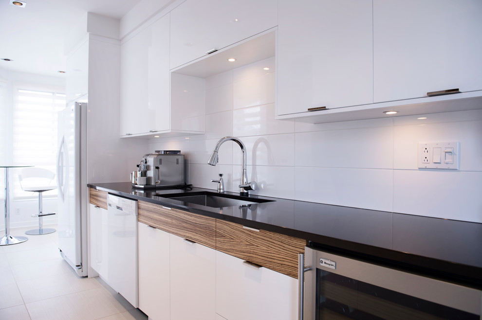 Small modern galley enclosed kitchen in Other with flat-panel cabinets, white cabinets, engineered stone countertops, white splashback, ceramic splashback, white appliances, porcelain flooring and no island.