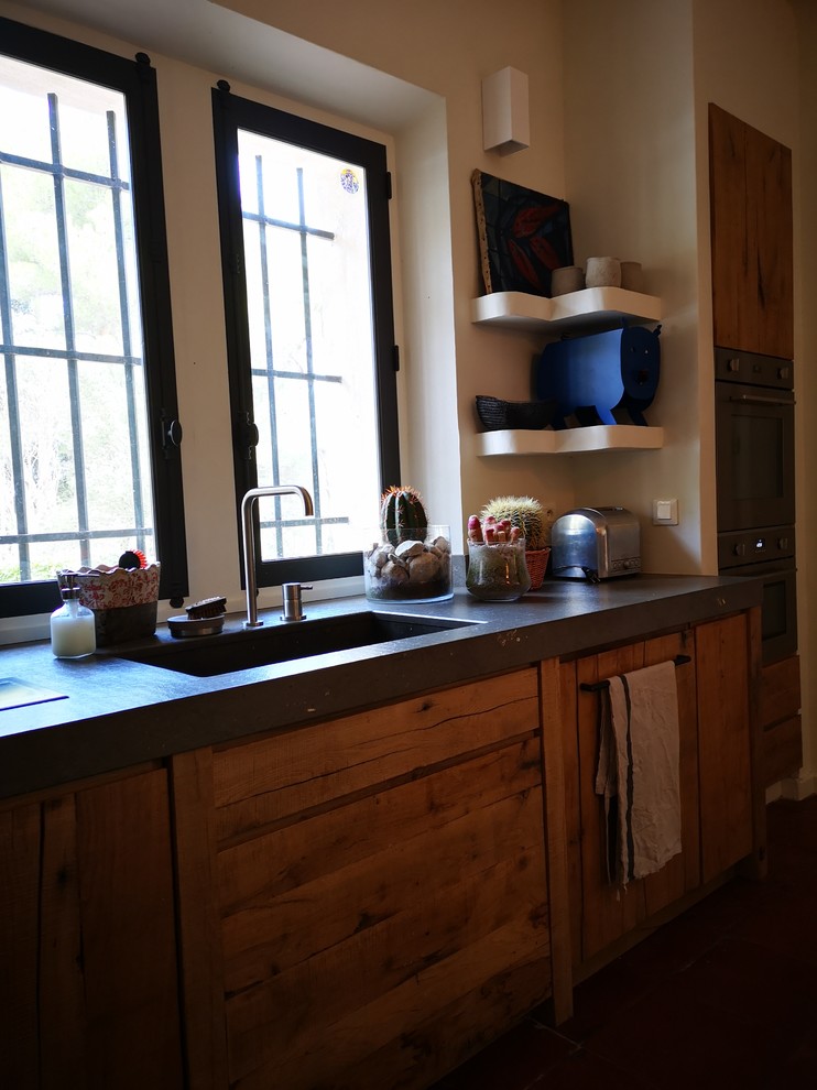Offene, Kleine Country Küche in L-Form mit integriertem Waschbecken, hellen Holzschränken, Granit-Arbeitsplatte, Küchengeräten aus Edelstahl, Terrakottaboden, Kücheninsel, rosa Boden und grauer Arbeitsplatte in Sonstige