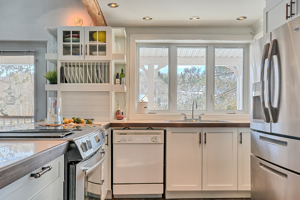 Foto på ett mellanstort eklektiskt kök, med en dubbel diskho, skåp i shakerstil, vita skåp, kaklad bänkskiva, vitt stänkskydd, fönster som stänkskydd, rostfria vitvaror, skiffergolv och en halv köksö