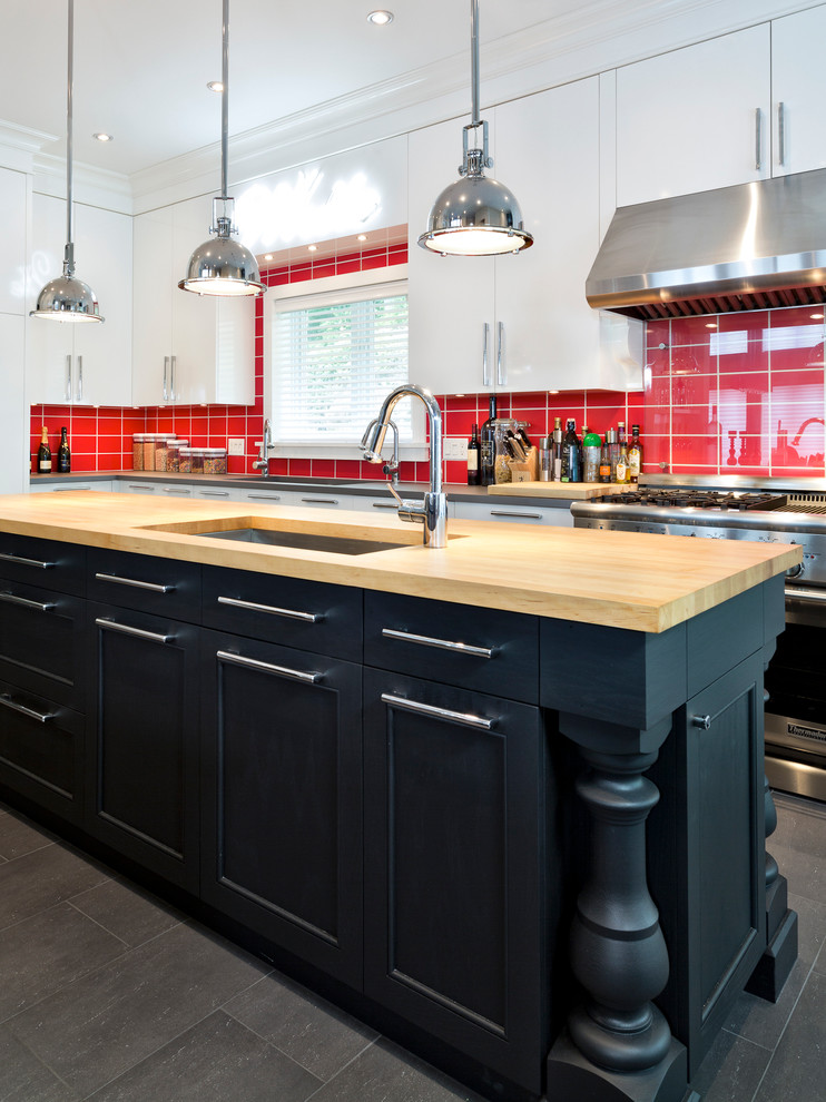 Foto di un cucina con isola centrale contemporaneo con lavello sottopiano, ante lisce, ante bianche, paraspruzzi rosso e elettrodomestici in acciaio inossidabile