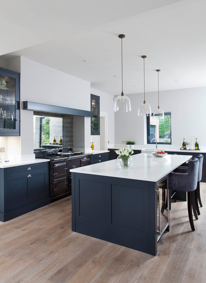 Imagen de cocina comedor lineal de estilo de casa de campo de tamaño medio con fregadero sobremueble, armarios estilo shaker, puertas de armario grises, encimera de cuarcita, salpicadero metalizado, salpicadero de vidrio templado, electrodomésticos de acero inoxidable, suelo de madera en tonos medios y una isla