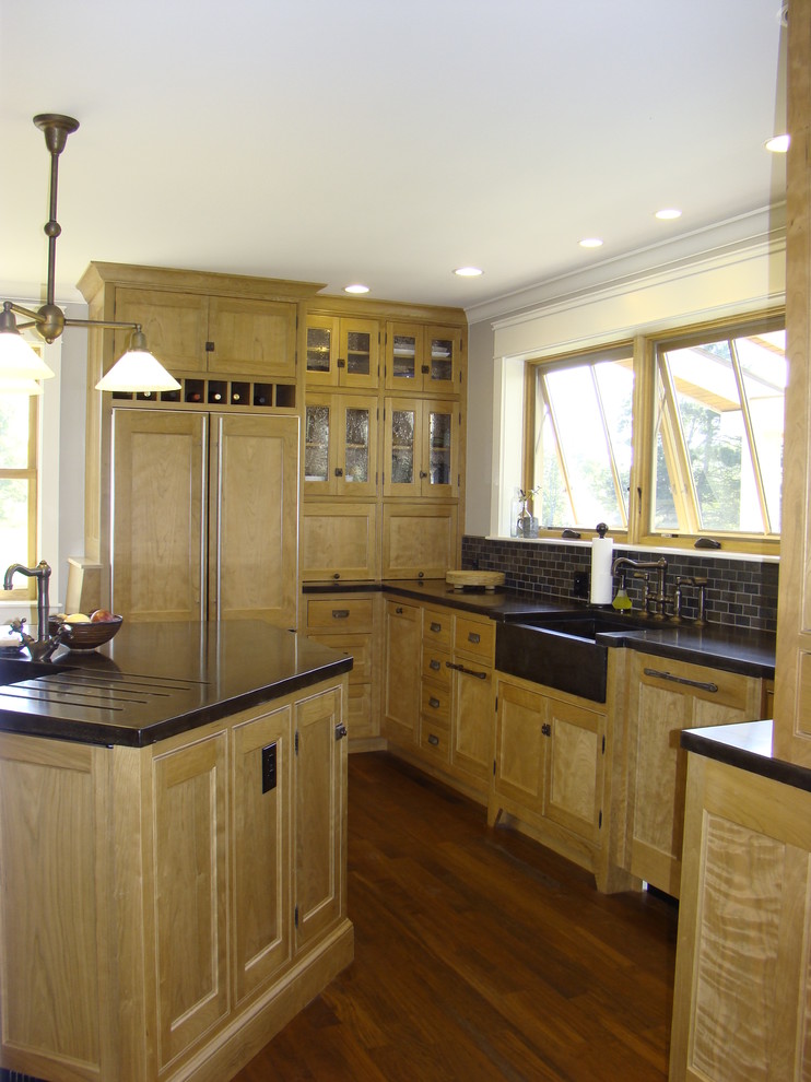 Example of a mid-sized arts and crafts l-shaped medium tone wood floor open concept kitchen design in Portland Maine with a farmhouse sink, beaded inset cabinets, medium tone wood cabinets, concrete countertops, gray backsplash, stone tile backsplash, paneled appliances and an island