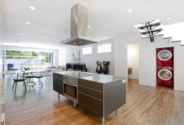 This is an example of a medium sized contemporary l-shaped open plan kitchen in San Francisco with flat-panel cabinets, grey cabinets, stainless steel worktops, stainless steel appliances, dark hardwood flooring, an island and brown floors.