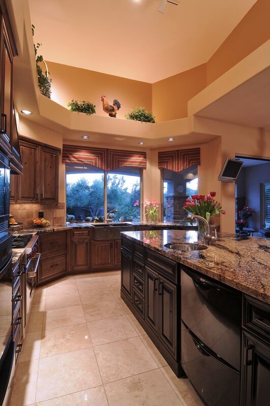 Foto på ett mellanstort lantligt kök, med en rustik diskho, luckor med upphöjd panel, skåp i mörkt trä, granitbänkskiva, beige stänkskydd, stänkskydd i stenkakel, integrerade vitvaror, travertin golv, en köksö och beiget golv