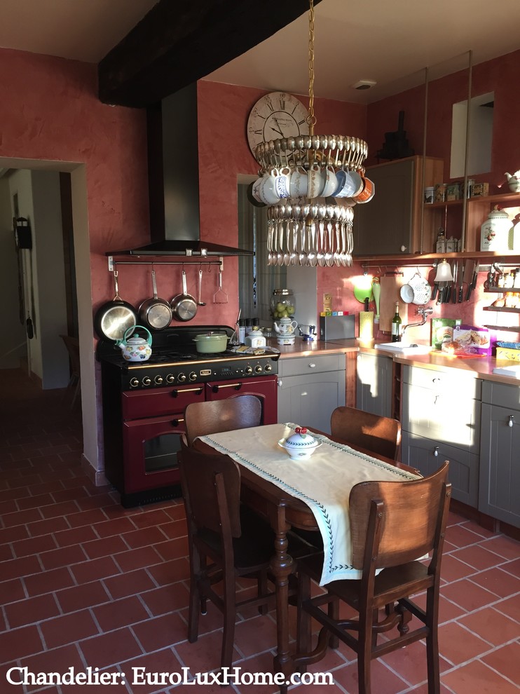 Idée de décoration pour une cuisine vintage en L fermée et de taille moyenne avec tomettes au sol.