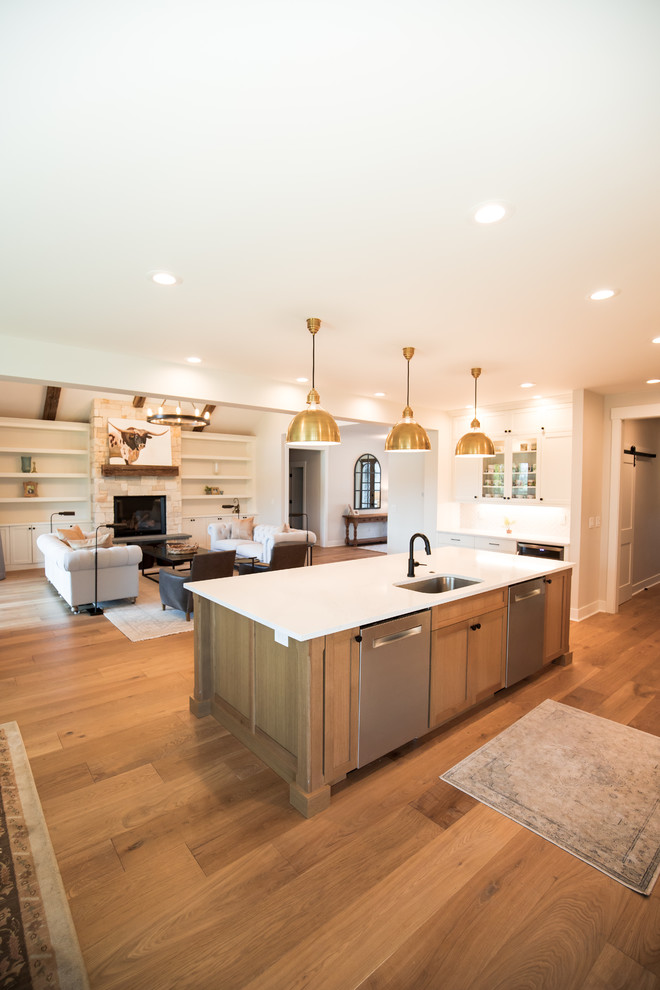 Large arts and crafts single-wall medium tone wood floor and brown floor eat-in kitchen photo in Portland with an integrated sink, recessed-panel cabinets, white cabinets, white backsplash, ceramic backsplash, stainless steel appliances, an island and white countertops