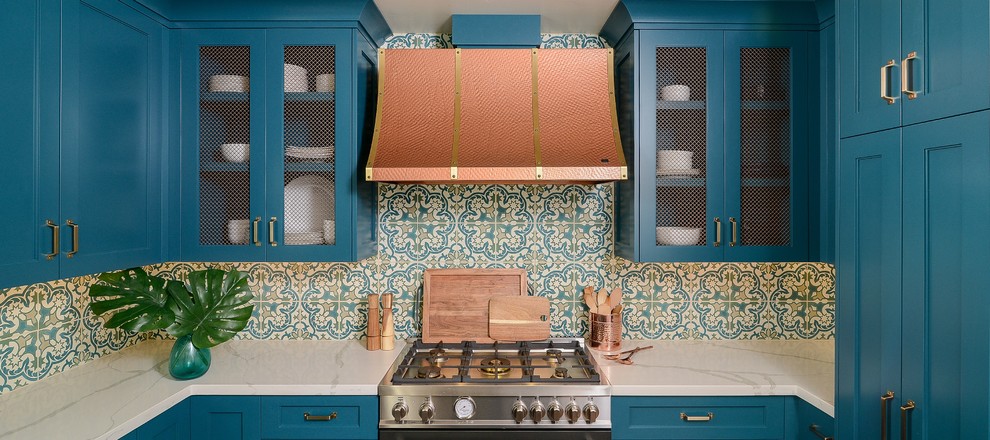 サクラメントにある地中海スタイルのおしゃれなアイランドキッチン (シェーカースタイル扉のキャビネット、ターコイズのキャビネット、人工大理石カウンター、テラコッタタイルの床、白いキッチンカウンター) の写真