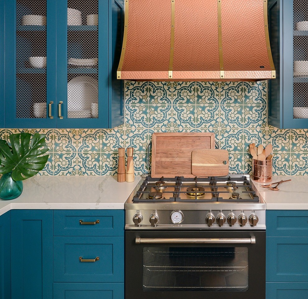 Exemple d'une cuisine méditerranéenne avec un placard à porte shaker, des portes de placard turquoises, un plan de travail en surface solide, tomettes au sol, îlot et un plan de travail blanc.