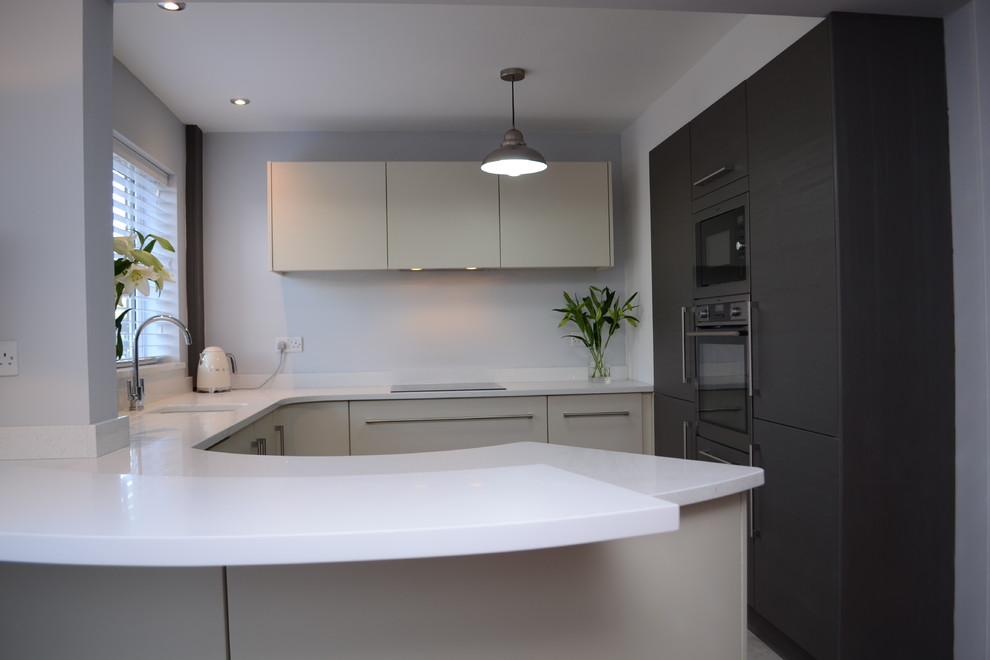Aménagement d'une cuisine ouverte contemporaine de taille moyenne avec un placard à porte plane et un électroménager en acier inoxydable.