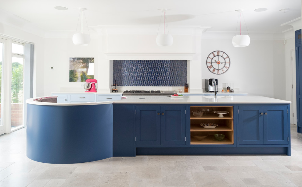 カーディフにある高級な広いトランジショナルスタイルのおしゃれなアイランドキッチン (シェーカースタイル扉のキャビネット、青いキャビネット、珪岩カウンター、青いキッチンパネル、モザイクタイルのキッチンパネル、ライムストーンの床、ベージュの床) の写真