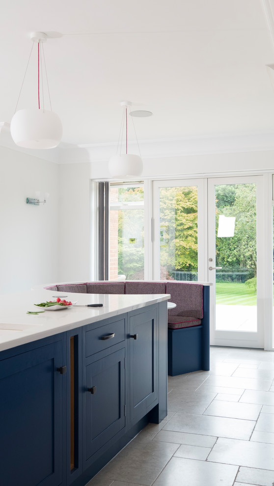 Large traditional single-wall open plan kitchen in Cardiff with shaker cabinets, blue cabinets, quartz worktops, blue splashback, mosaic tiled splashback, coloured appliances, limestone flooring, an island and grey floors.
