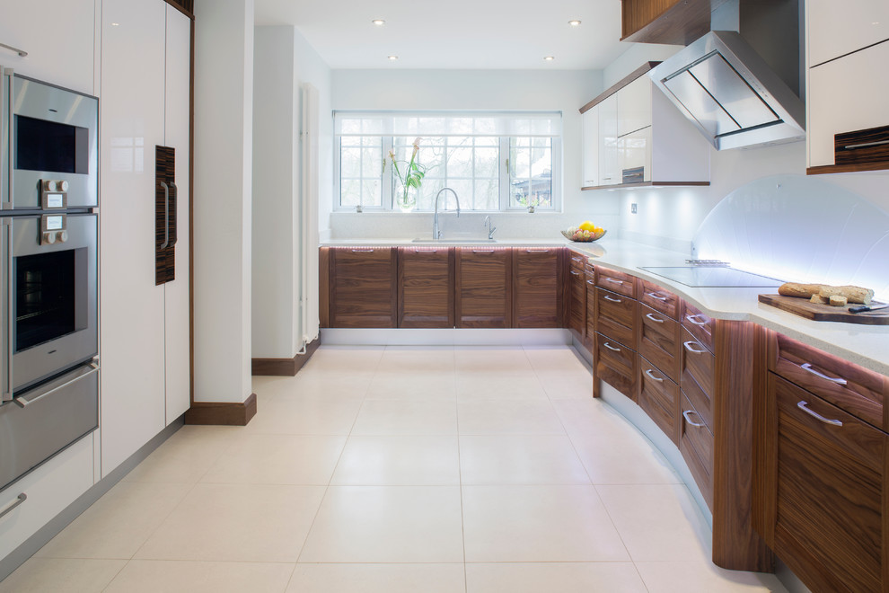 Moderne Küche in U-Form mit dunklen Holzschränken, Schrankfronten mit vertiefter Füllung, Küchenrückwand in Weiß und Küchengeräten aus Edelstahl in Sonstige