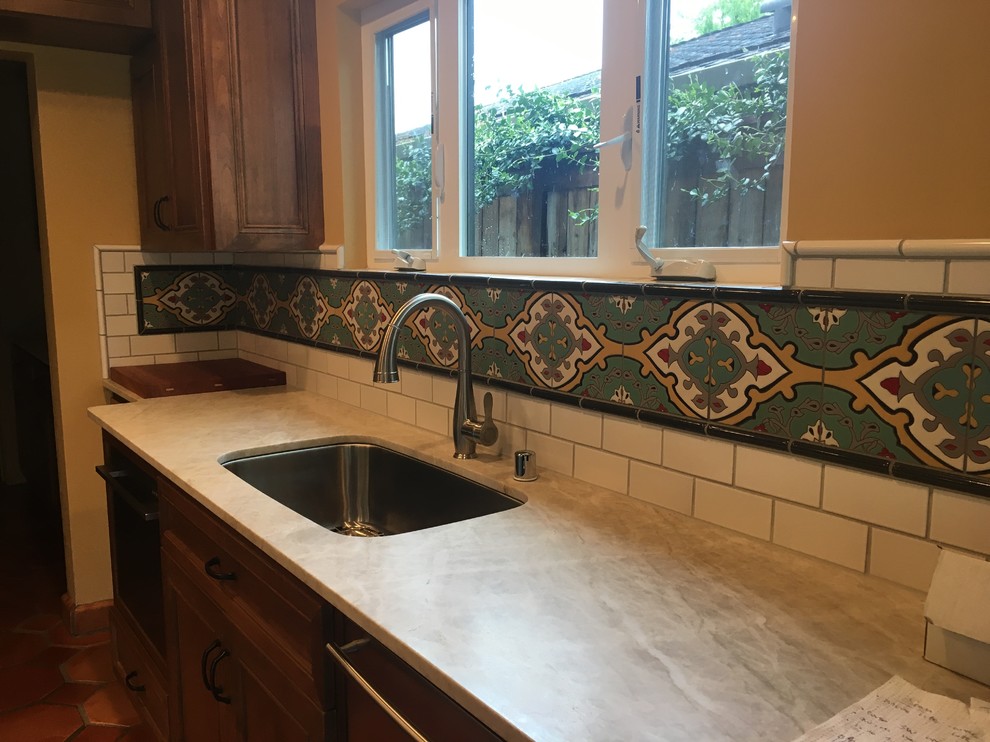 Inspiration for a medium sized mediterranean single-wall kitchen/diner in Sacramento with medium wood cabinets, white splashback, ceramic splashback, stainless steel appliances, a submerged sink, engineered stone countertops, terracotta flooring, beaded cabinets, no island and beige floors.
