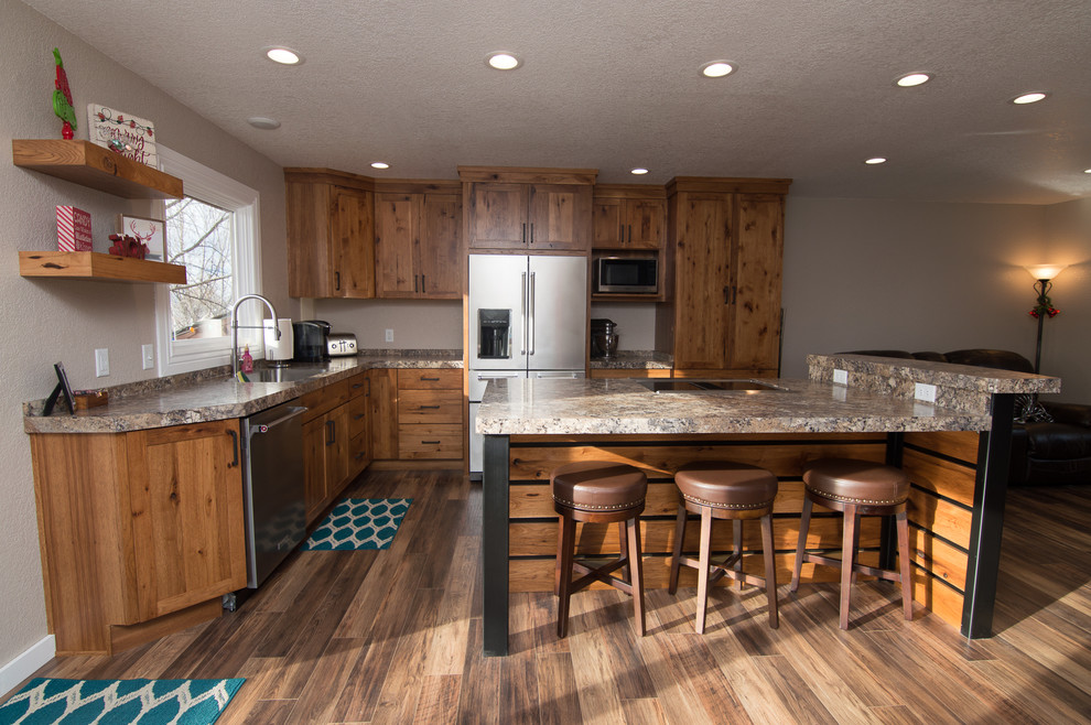 Medium sized traditional l-shaped kitchen/diner in Other with an integrated sink, shaker cabinets, medium wood cabinets, laminate countertops, stainless steel appliances, medium hardwood flooring, an island, brown floors and beige worktops.
