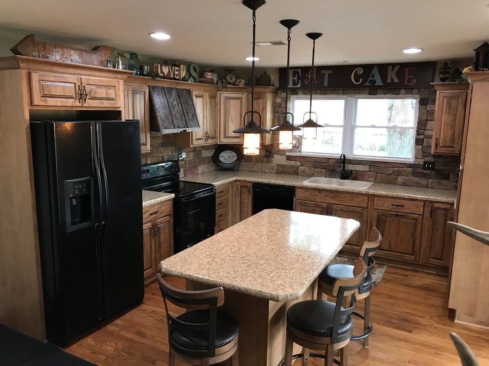 Inspiration for a kitchen remodel in Indianapolis with a drop-in sink, raised-panel cabinets, medium tone wood cabinets, laminate countertops, black appliances and an island