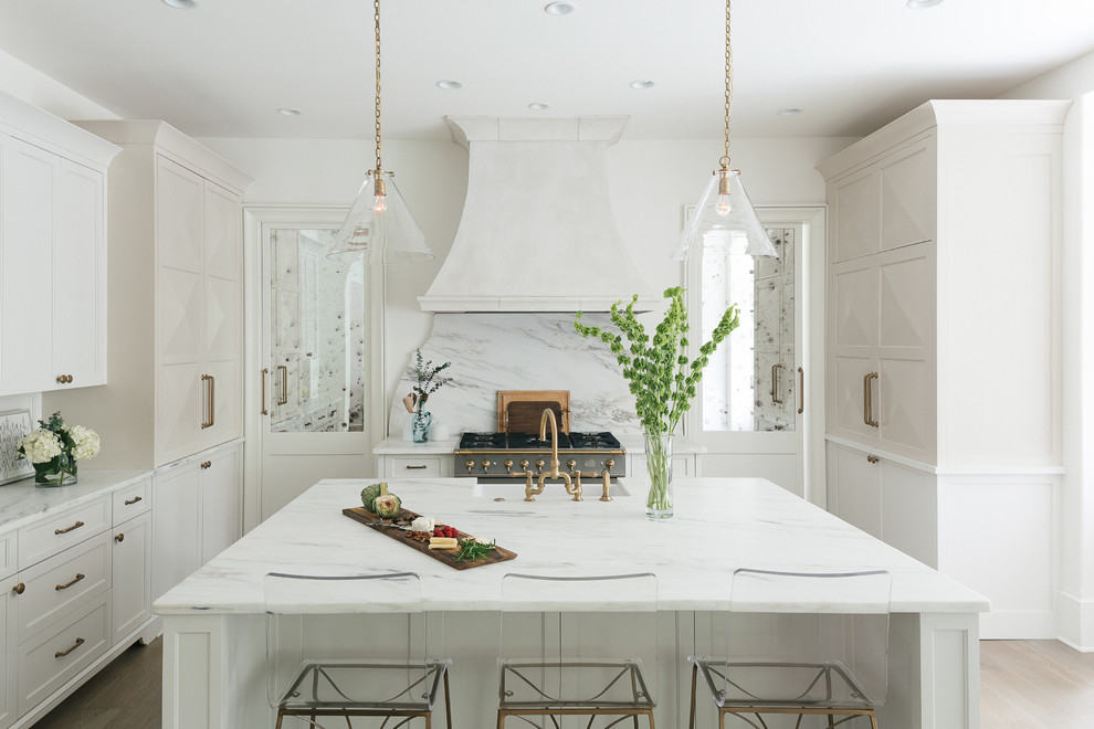 Inredning av ett klassiskt stort kök, med en rustik diskho, skåp i shakerstil, vita skåp, marmorbänkskiva, vitt stänkskydd, stänkskydd i marmor, rostfria vitvaror, mörkt trägolv, en köksö och brunt golv