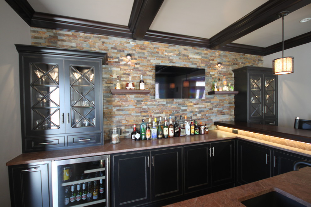 Inspiration for a modern l-shaped home bar in New York with a submerged sink, shaker cabinets, black cabinets, wood worktops, multi-coloured splashback and stone tiled splashback.