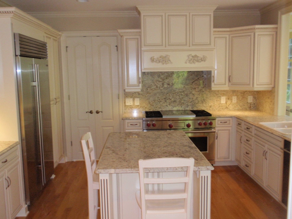 Exempel på ett mellanstort modernt kök, med vita skåp, granitbänkskiva, grått stänkskydd, stänkskydd i sten, rostfria vitvaror, en köksö, en nedsänkt diskho och mellanmörkt trägolv
