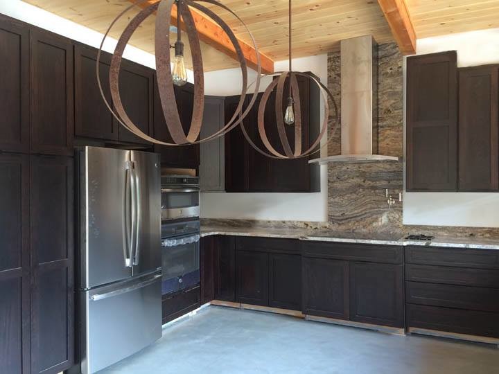 Foto di una cucina minimal di medie dimensioni con ante con riquadro incassato, ante in legno bruno, top in granito e elettrodomestici in acciaio inossidabile
