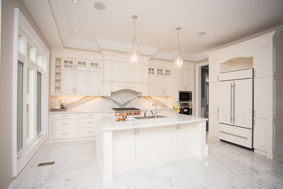 Bild på ett stort funkis u-kök, med en undermonterad diskho, luckor med upphöjd panel, vita skåp, granitbänkskiva, rostfria vitvaror och en köksö
