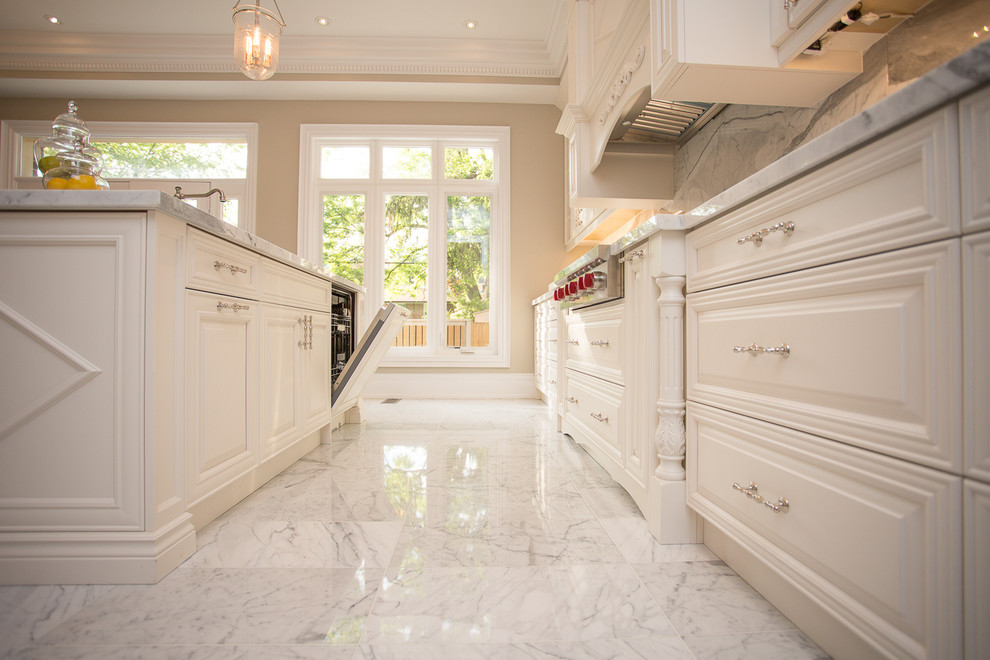 Modern inredning av ett stort l-kök, med en undermonterad diskho, luckor med upphöjd panel, vita skåp, granitbänkskiva, rostfria vitvaror och en köksö