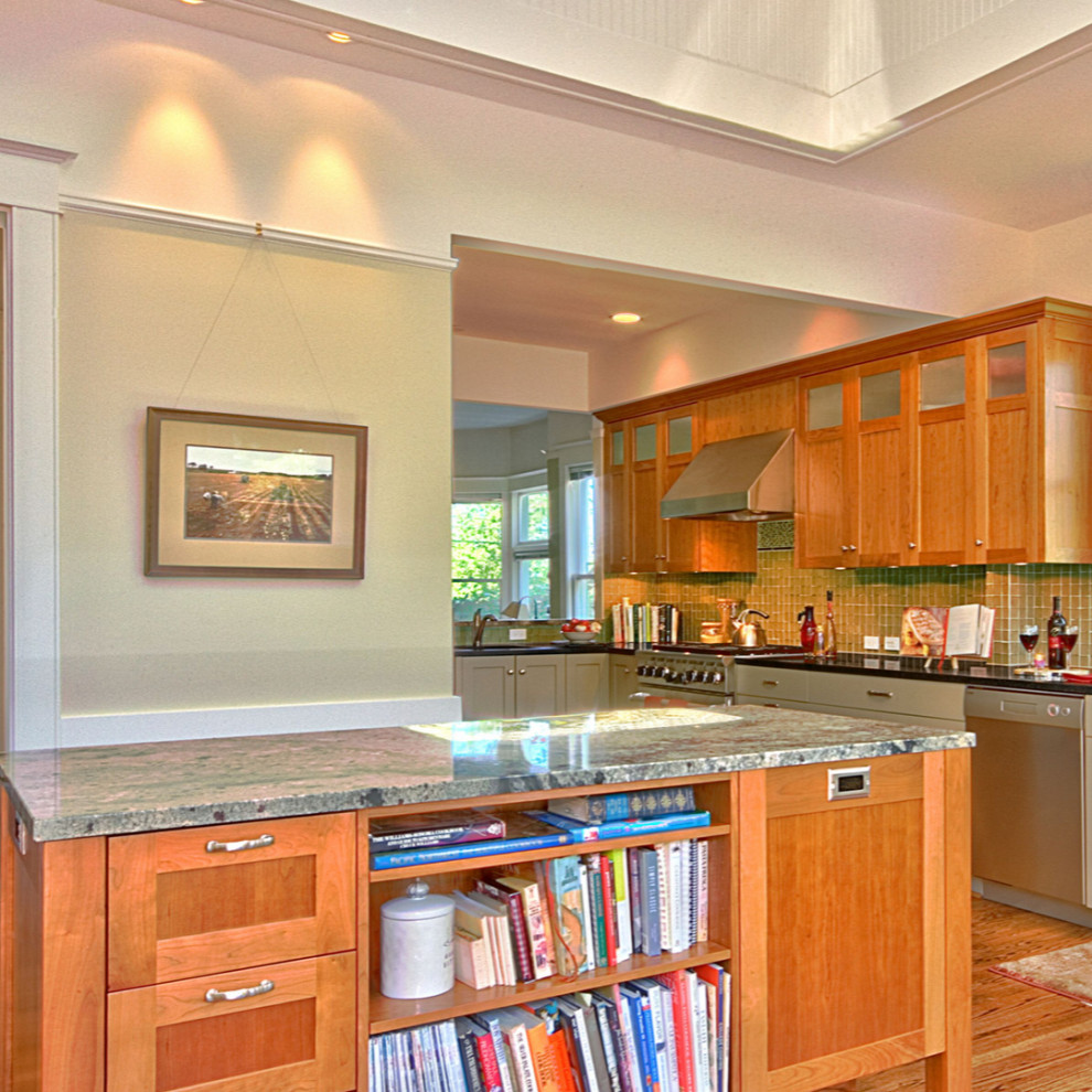 Example of a mid-sized arts and crafts u-shaped medium tone wood floor and brown floor eat-in kitchen design in Seattle with an undermount sink, shaker cabinets, light wood cabinets, gray backsplash, glass tile backsplash, stainless steel appliances, a peninsula and black countertops