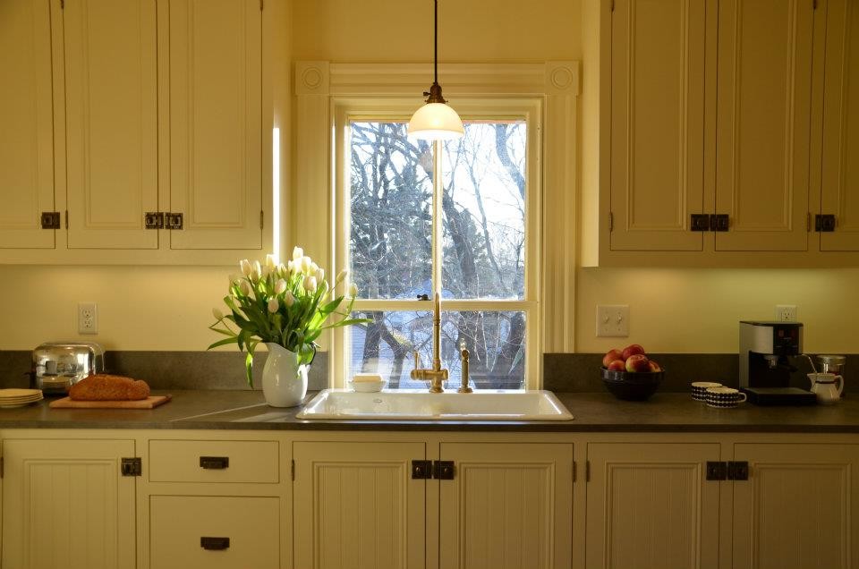 Esempio di una cucina di medie dimensioni con lavello stile country, ante a filo, ante bianche, top in superficie solida e paraspruzzi bianco