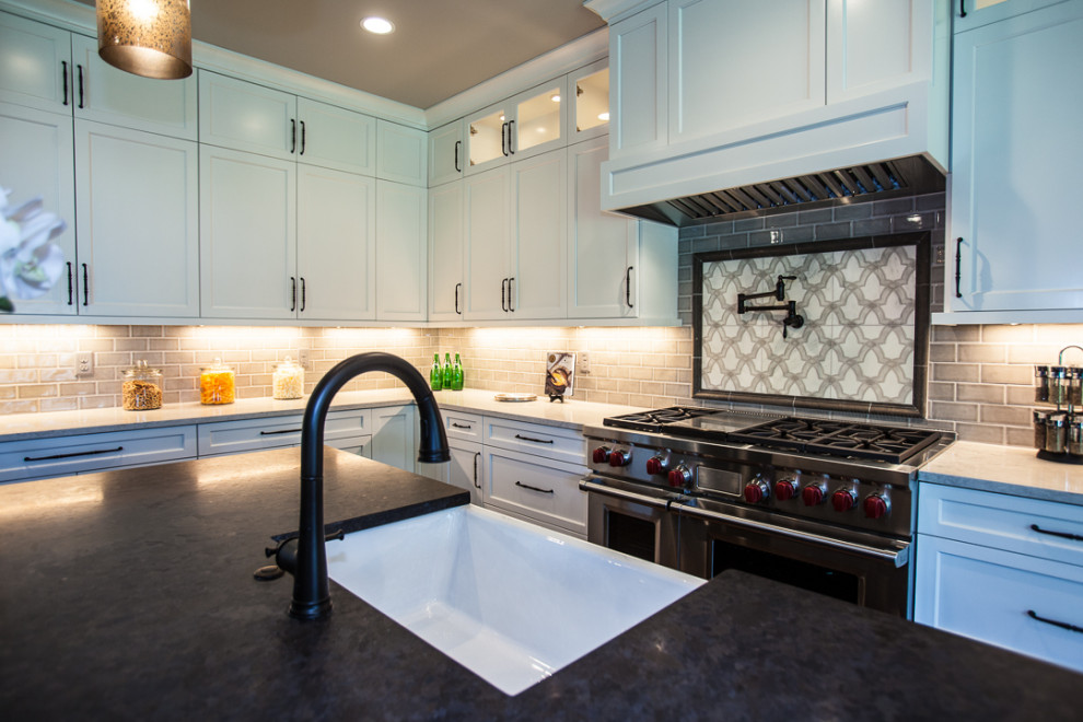Klassisk inredning av ett stort flerfärgad flerfärgat kök, med en rustik diskho, luckor med infälld panel, vita skåp, granitbänkskiva, beige stänkskydd, stänkskydd i stenkakel, integrerade vitvaror, mörkt trägolv, en köksö och brunt golv