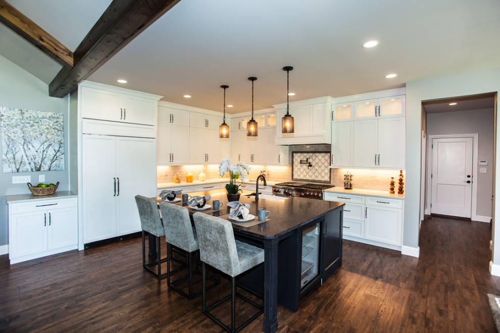 Exempel på ett stort klassiskt flerfärgad flerfärgat kök, med en rustik diskho, luckor med infälld panel, vita skåp, granitbänkskiva, beige stänkskydd, stänkskydd i stenkakel, integrerade vitvaror, mörkt trägolv, en köksö och brunt golv
