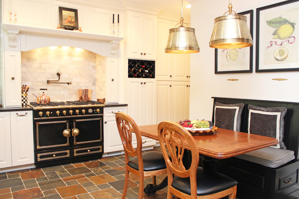 Eat-in kitchen - traditional eat-in kitchen idea in New York with black appliances, raised-panel cabinets, stone tile backsplash, white backsplash and white cabinets